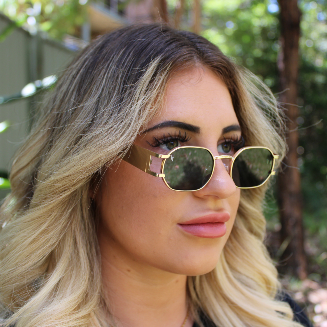 woman wearing gold forest green sunglasses