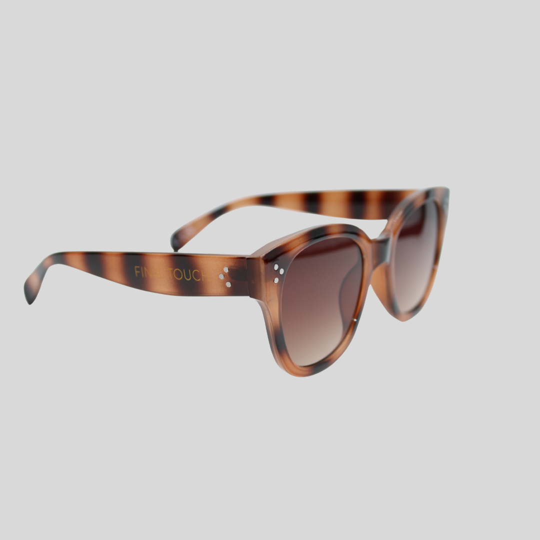 nicky tortoiseshell brown front Angled side view of tortoiseshell brown sunglasses with soft square frames, brown gradient lenses, and branded temple detailing on a light background.