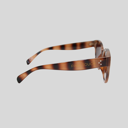 Nicky tortoiseshell Side profile of tortoiseshell brown sunglasses showing curved arms, brown gradient lenses, and gold Final Touch branding on the temple against a light background.